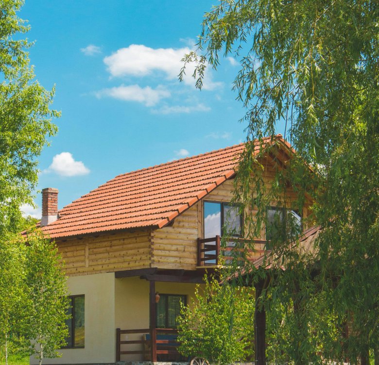 Home with a red tile roof surrounded by trees